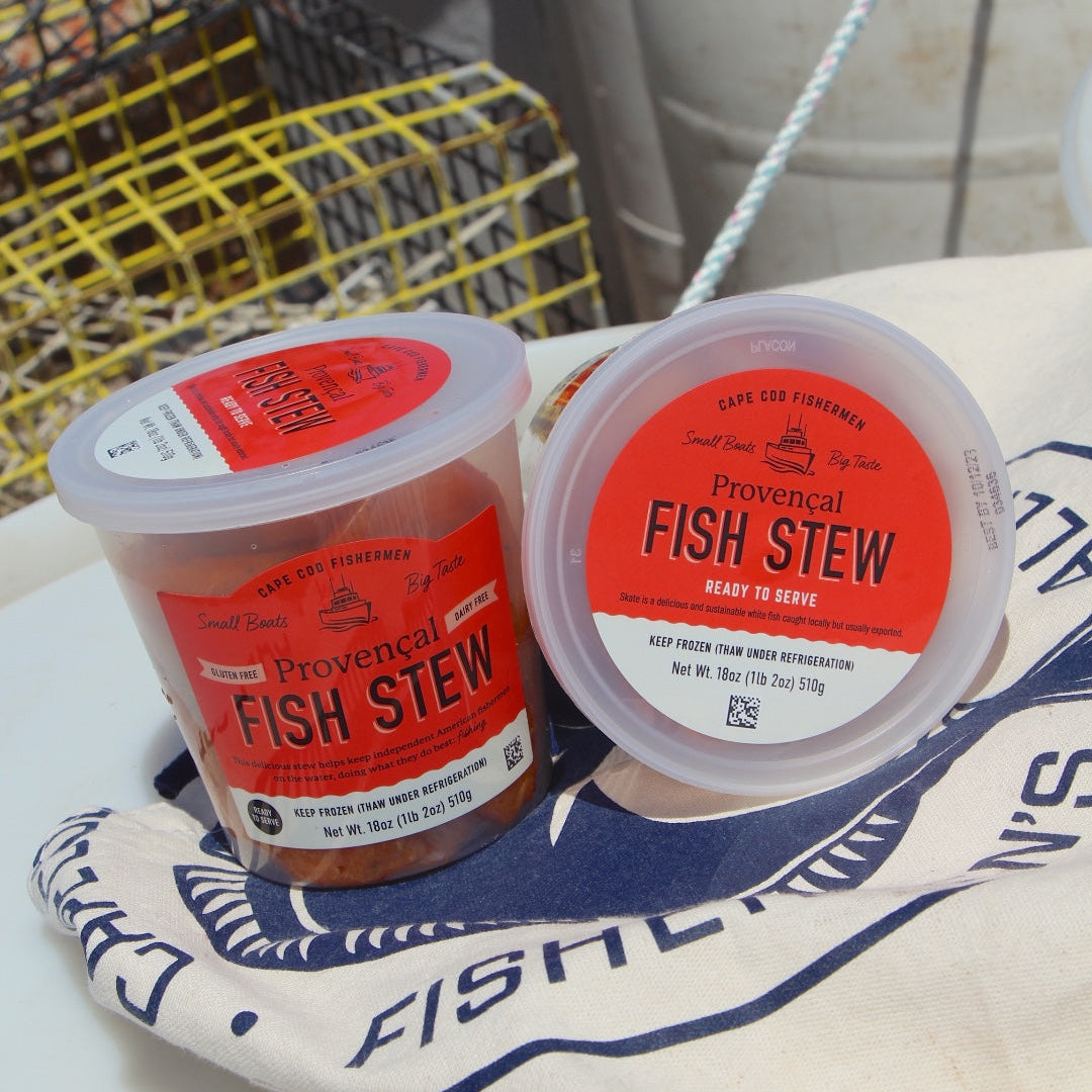 Two containers of Provençal Fish Stew on a fishing-themed towel.