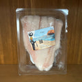 Packaged fish fillet with a label on a wooden surface